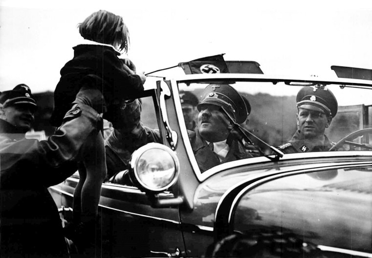 Adolf Hitler greets a child from his car during his tour to the Westwall installations